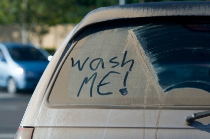 car with "wash me" written on the dirty window
